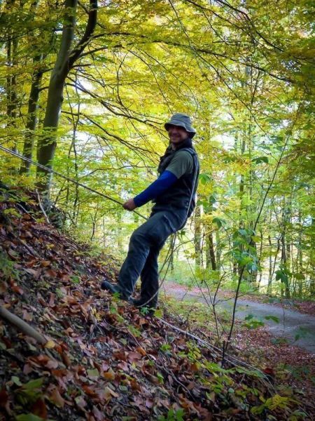 Seil wird an einem Hang gesichert, während eine Person sich abseilt