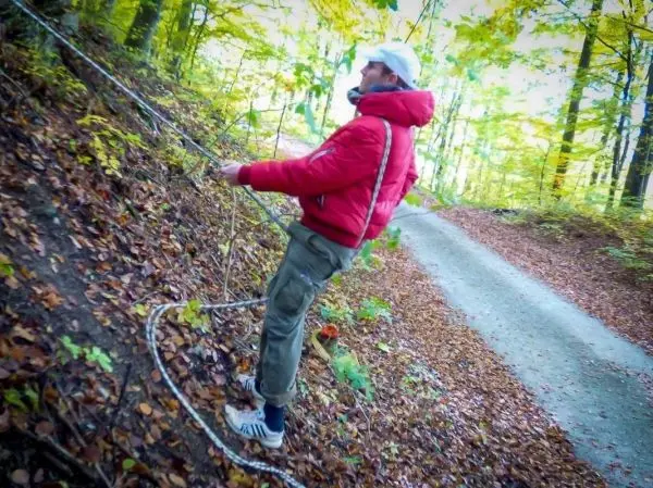 Seil wird an einem Hang gespannt, während eine Person daran zieht