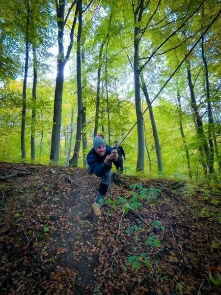 Seil wird von einer Person in einem bewaldeten Gebiet gespannt