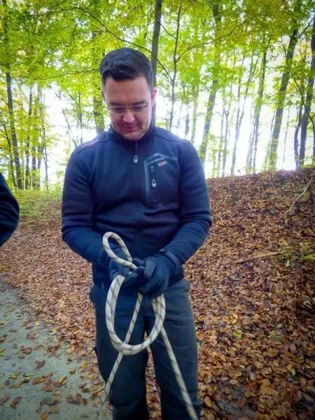 Seil wird zu einer Schlaufe geformt, während Laub im Hintergrund liegt