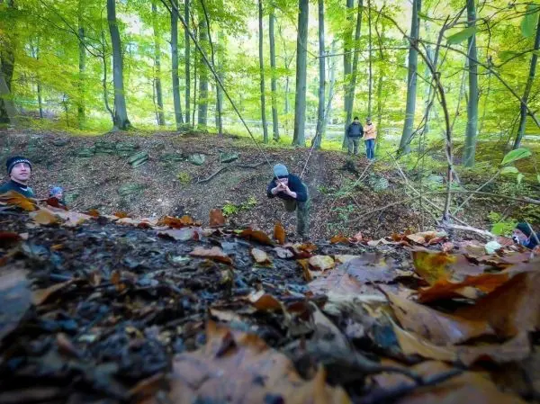 Seilbrücke über einen Graben mit Teilnehmern im Wald