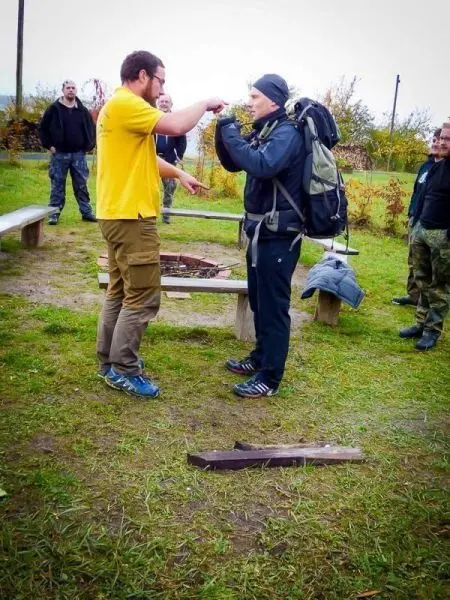 Zwei Personen demonstrieren eine Technik im Freien, während andere zuschauen