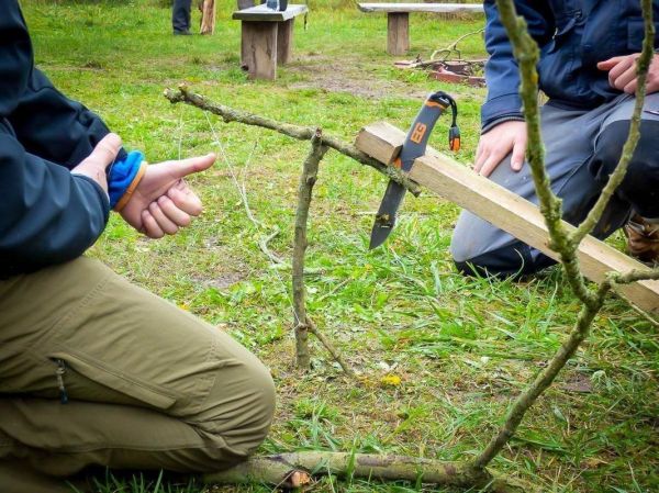 Zweig wird mit einem Messer bearbeitet, um eine Konstruktion zu erstellen