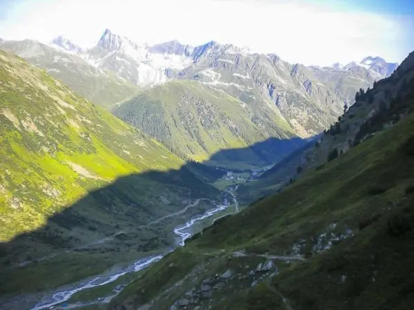 Berglandschaft mit grünen Hängen und einem Fluss im Tal zwischen den Bergen