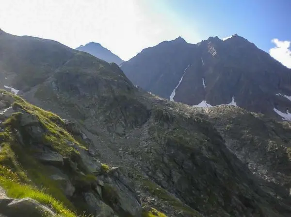 Berglandschaft mit steilen Felsen und schneebedeckten Gipfeln im Hintergrund