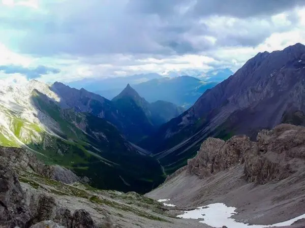 Berglandschaft mit steilen Hängen, Tälern und schneebedeckten Flächen