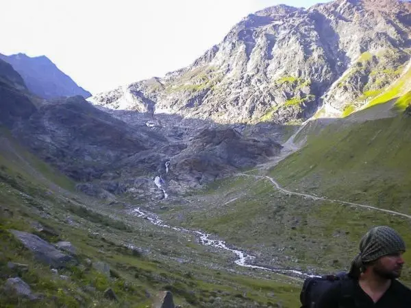 Berglandschaft mit steilen Hängen und einem kleinen Wasserlauf im Tal
