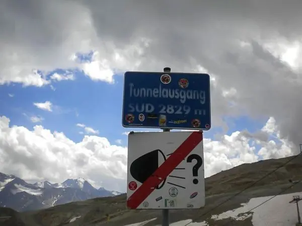 Blaues Schild mit der Aufschrift „Tunnelausgang Süd 2829 m“ und Symbolen