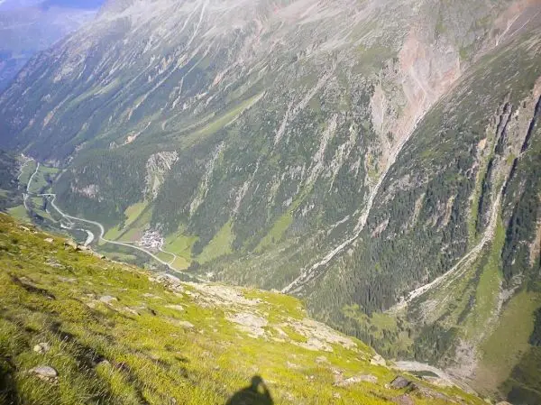 Blick auf eine grüne Berglandschaft mit steilen Hängen und einem Tal