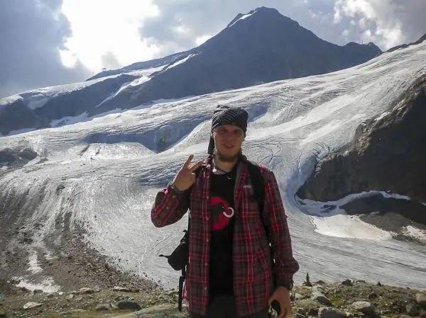 Mann posiert vor einem Gletscher und Berglandschaft