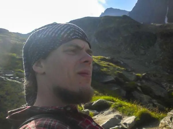 Person mit kopftuch und bart in einer berglandschaft