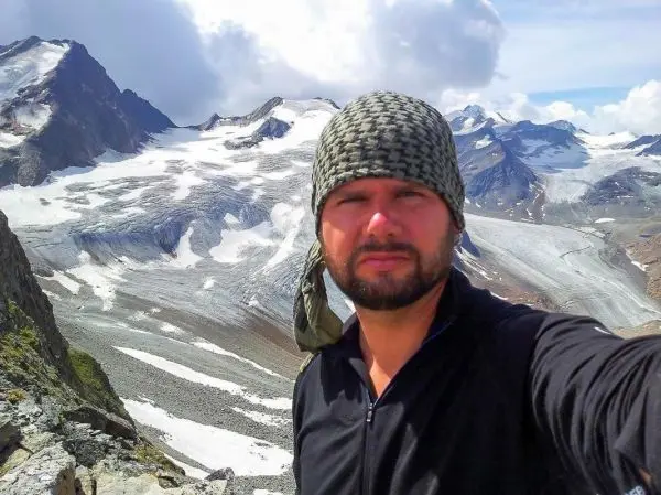 Selbstporträt vor einer beeindruckenden Berglandschaft mit Gletschern und Felsen