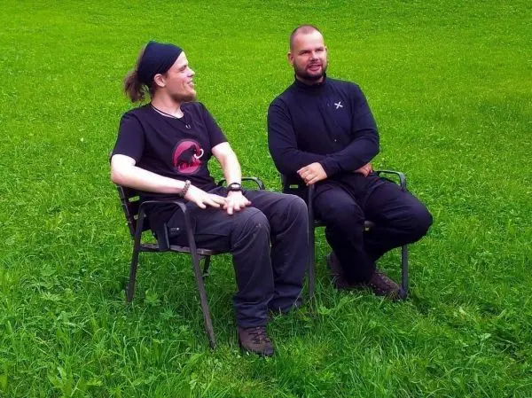 Zwei Personen sitzen auf Klappstühlen auf einer grünen Wiese