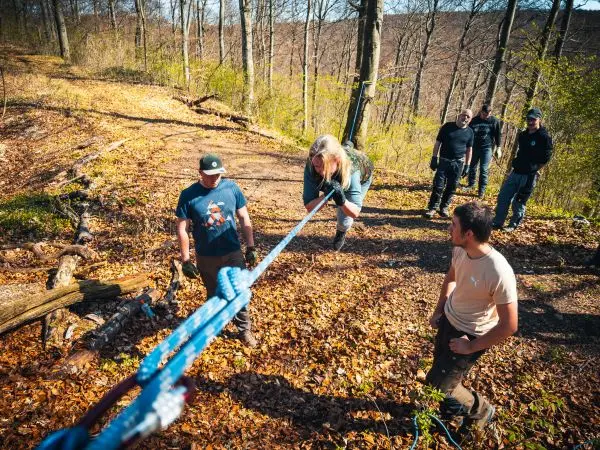 Seilquerung mit selbstgebautem Seil und mehreren Personen im Wald