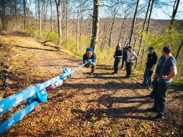 Seilquerung mit selbstgebautem Seil und mehreren Personen im Wald