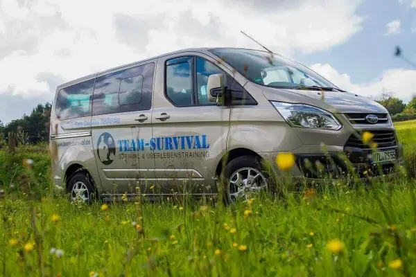 Fahrzeug steht auf einer Wiese mit Blumen im Vordergrund