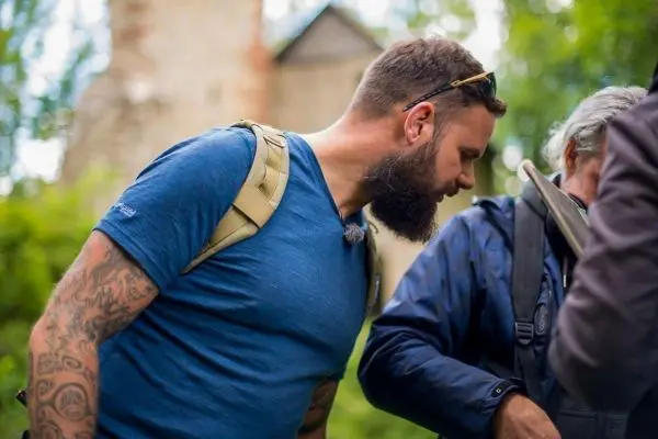 Zwei Personen betrachten Ausrüstung im Freien, eine trägt einen Rucksack
