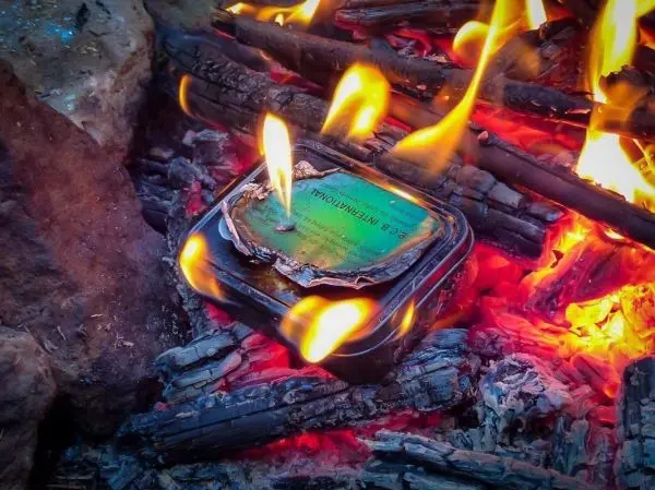 Kleine Flamme brennt auf einer Metallbox im Feuer