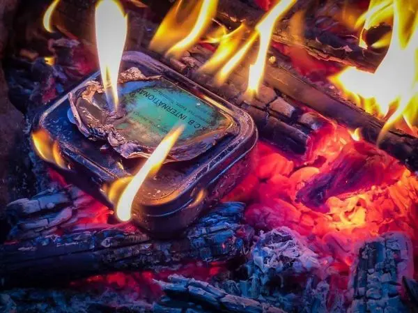 Kleine Flamme brennt in einer Feuerstelle mit glühenden Kohlen