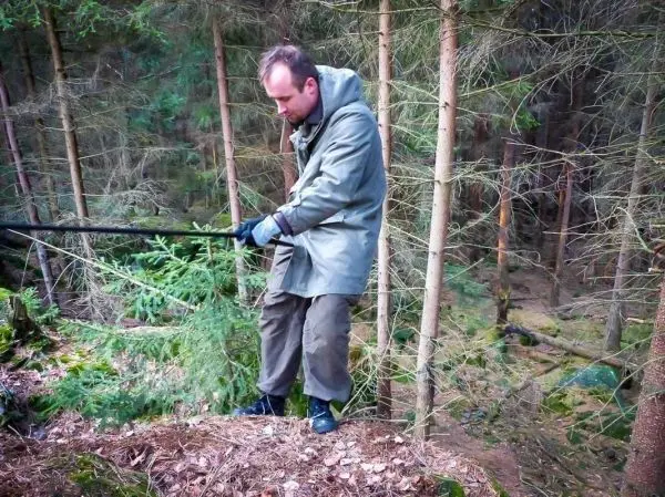 Mann zieht an einem Seil, während er auf einem Hang steht