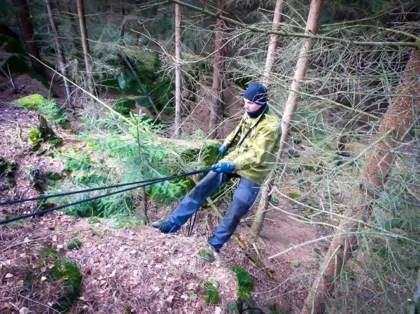 Selbstgebaute Seilquerung wird von einer Person mit Seil und Handschuhen überquert