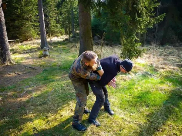 Zwei Personen üben eine Technik zur Kontrolle in einem Waldgebiet
