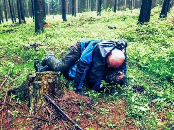 Person liegt auf einer anderen Person im Wald