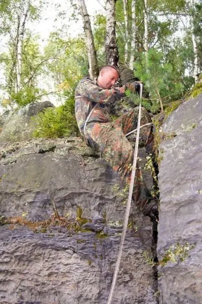Seilquerung an einer Felswand mit einem Seil in der Hand