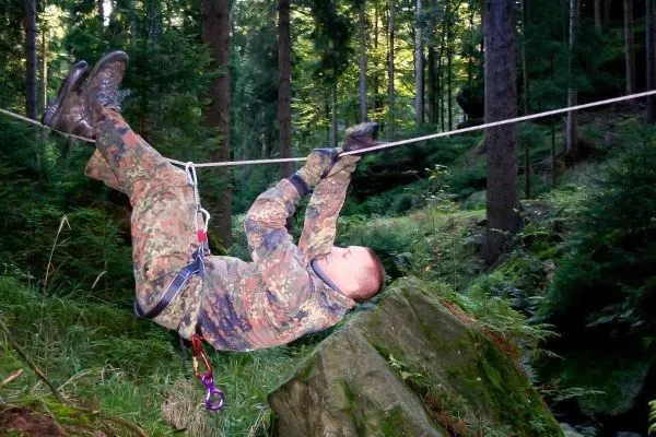 Seilquerung über einen Felsen im Wald mit Sicherungsgerät
