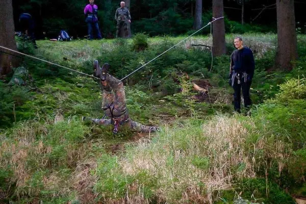 Selbstgebaute Seilquerung mit hängendem Gewicht und zwei Personen im Hintergrund