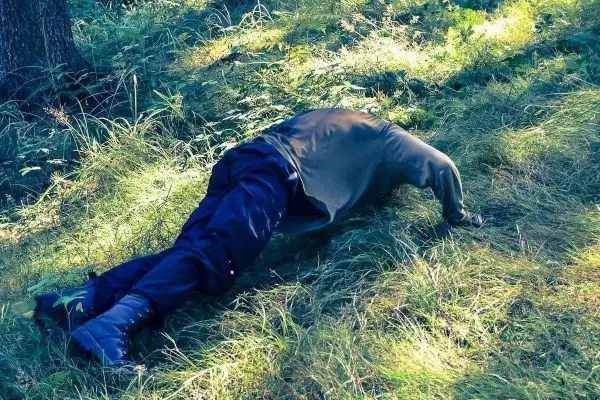 Person liegt auf dem Boden im Gras