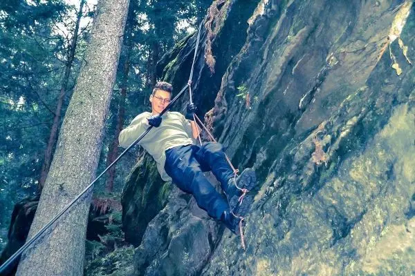 Person seilt an einem Seil an einer Felswand ab
