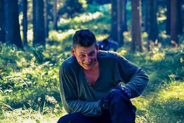 Person sitzt im gras und schaut in die kamera