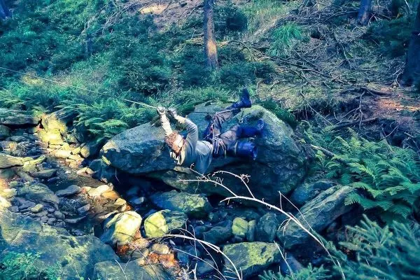 Person überquert einen kleinen Bach mit einer Seilquerung