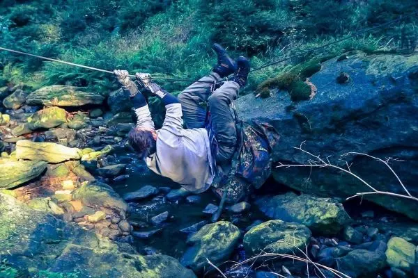 Seilquerung über einen Bach mit selbstgebauter Seilbrücke und Sicherungsgurt