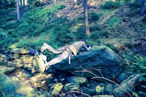 Selbstgebaute Seilquerung über einen Felsen in einem Waldgebiet