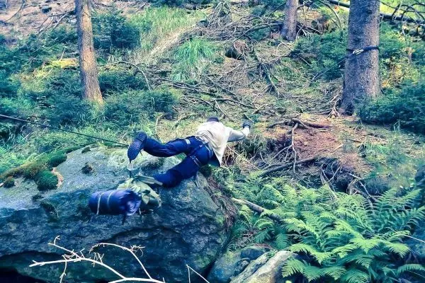 Selbstgebaute Seilquerung über einen großen Stein im Wald