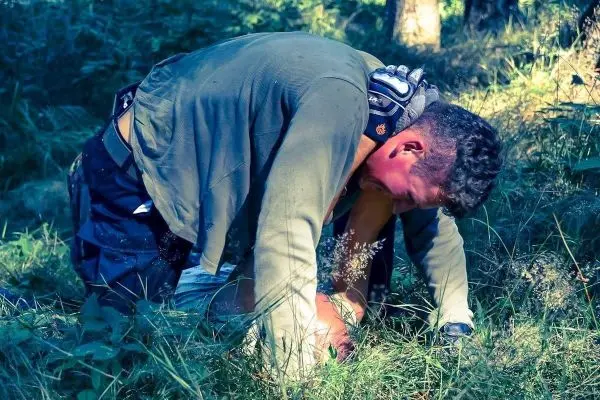 Zwei Personen in einer natürlichen Umgebung, eine Person kniet über der anderen