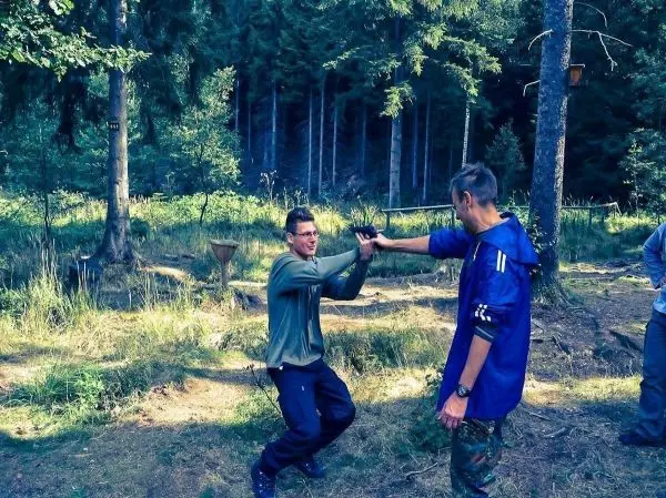 Zwei Personen üben eine Selbstverteidigungstechnik im Wald