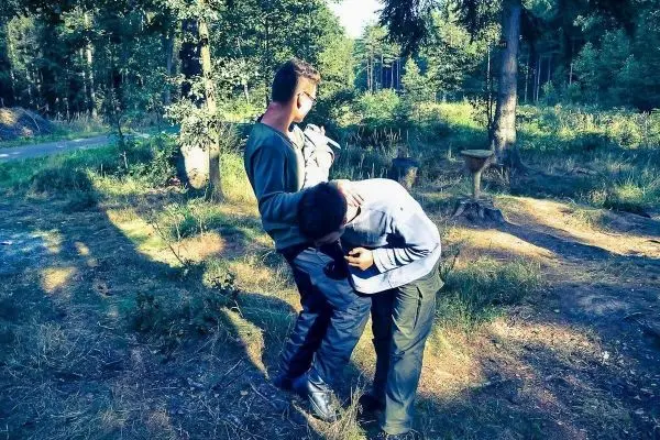 Zwei Personen üben eine Technik zur Befreiung aus einer Umklammerung im Wald