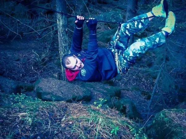 Person schwingt an einem Seil über Steine beim Überlebenstraining