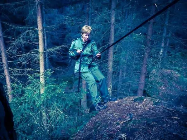 Person überquert eine selbstgebaute Seilbrücke zwischen Bäumen