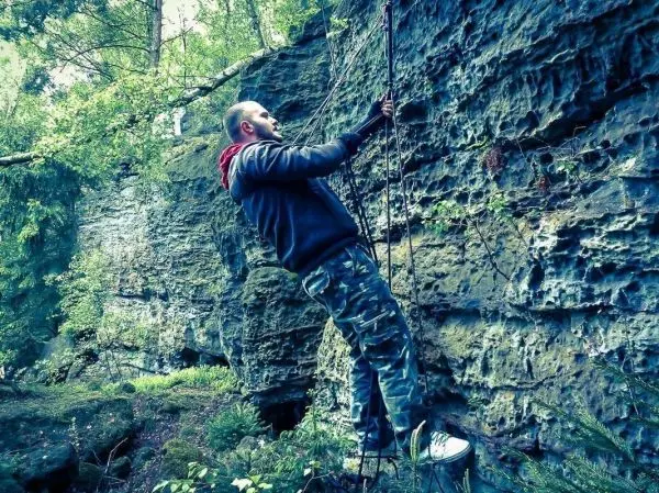 Seilquerung an einer Felswand mit Kletterausrüstung und Sicherungsseil
