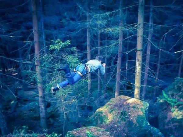 Selbstgebaute Seilquerung zwischen Bäumen wird überquert