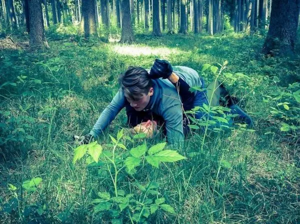 Zwei Personen liegen im Gras, eine Person hält die andere fest