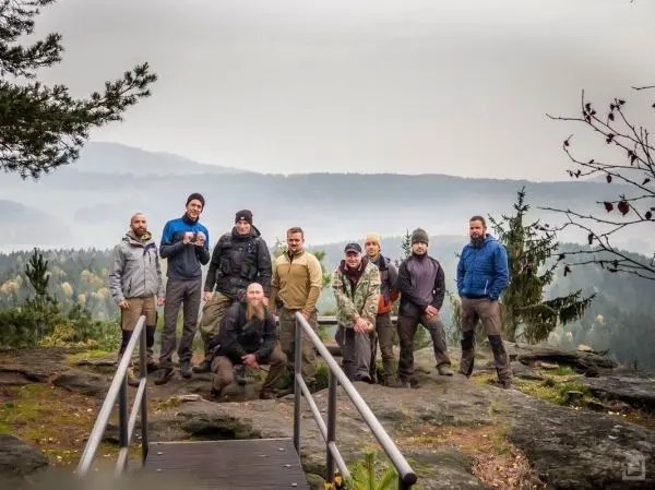 Gruppe steht auf einer Felsplattform mit Aussicht auf bewaldete Hügel