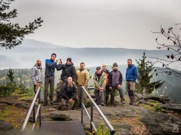 Gruppe von Personen posiert auf einer Aussichtsplattform im Wald