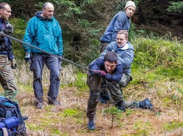 Gruppierung zieht an einem Seil, während eine Person sich nach vorne beugt