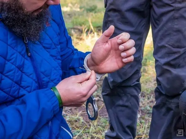 Hände binden eine Schnur um einen Gegenstand im Freien