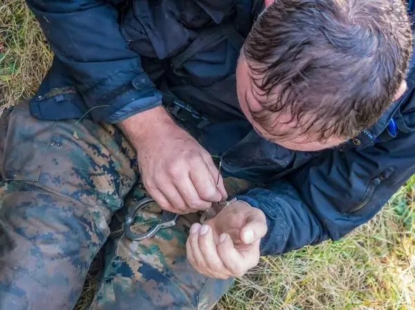 Hände mit Handschellen werden auf dem Boden gesichert